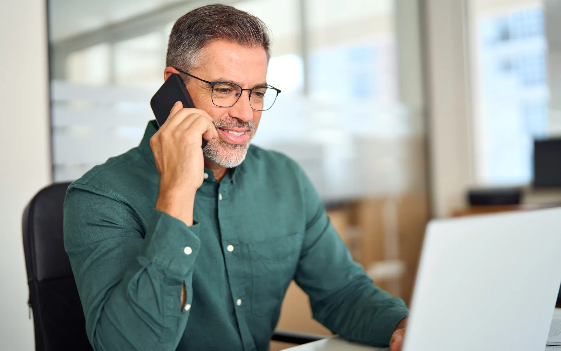 Man at computer making phone call Man at computer making phone call